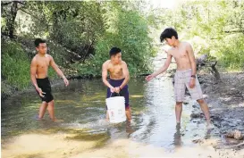  ?? JIM GENSHEIMER/STAFF ?? Mark Pablo, 16, left, Samson Truong, 14, and Nam Do, 15, form a brigade to retrieve water from Penitencia Creek to fill buckets in a bid to raise awareness about access to freshwater.
