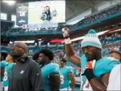  ?? WILFREDO LEE — THE ASSOCIATED PRESS ?? Miami Dolphins defensive end Robert Quinn (94) raises his right fist during the singing of the national anthem before the team’s preseason game against the Tampa Bay Buccaneers last Thursday.