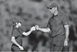  ?? Douglas P. DeFelice / Getty Images ?? Tiger Woods shares a fist bump with his son Charlie during Friday’s Pro-Am ahead of the PNC Championsh­ip on Saturday in Orlando, Fla.