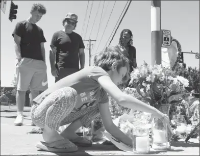  ?? Associated Press ?? Portland: Coco Douglas, 8, leaves a handmade sign and rocks she painted at a memorial in Portland, Ore., on Saturday, for two bystanders who were stabbed to death Friday while trying to stop a man who was yelling anti-Muslim slurs and acting aggressive­ly toward two young women. From left are Coco's brother, Desmond Douglas; her father, Christophe­r Douglas; and her stepmother, Angel Sauls.