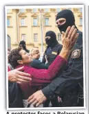  ??  ?? A protester faces a Belarusian serviceman at Sunday’s rally.