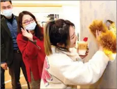  ?? CHEN FEI / XINHUA ?? Customers wait in line to be greeted by a server wearing a bear paw at the Hinichijou cafe in Shanghai in February. The cafe, which employs people with disabiliti­es, is expected to open up to 100 outlets across the country.