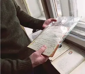  ?? AFP PIC ?? Historian Mikhail Melnichenk­o displaying pages from a Soviet-era diary in Moscow.
