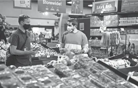  ?? PHOTOS BY COURTNEY HERGESHEIM­ER/COLUMBUS DISPATCH ?? Brian Zimmerman, left, a caseworker at Community Refugee and Immigratio­n Services, helps Naseer Durrani during his first visit to an American grocery store.