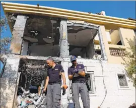  ?? Abir Sultan EPA/Shuttersto­ck ?? POLICE EXAMINE a house in Beersheba, Israel, said to be hit by a rocket from the Gaza Strip. A woman and three kids left before it was struck, officials said.