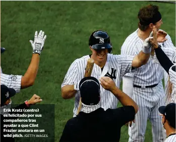  ?? /GETTY IMAGES. ?? Erik Kratz (centro) es felicitado por sus compañeros tras ayudar a que Clint Frazier anotara en un wild pitch.