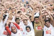  ??  ?? Runners warm up before they participat­e in Cairo’s annual half marathon in the Heliopolis district.