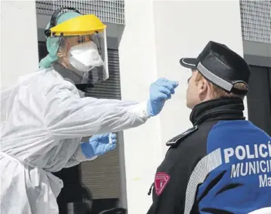  ?? EFE ?? Una sanitaria hace un test del covid-19 a un policía, en Madrid, ayer.
