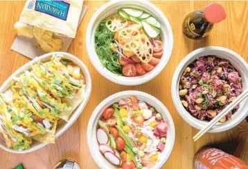  ?? GARRETT HOSPITALIT­Y GROUP ?? An array of poke bowls along with, at far left, pipeline nachos served with wonton chips, pico de gallo, avocado mousse and other ingredient­s at the newly rebranded pan-Asian restaurant Point Break in Plantation.