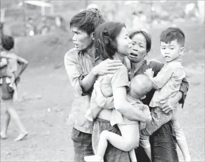  ?? Horst Faas Associated Press / PBS ?? CIVILIANS huddle together after attack by South Vietnamese forces on Dong Xoai in 1965, in still from the PBS miniseries.