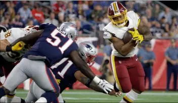  ??  ?? Washington Redskins running back Derrius Guice (right) evades New England Patriots linebacker Ja’Whaun Bentley (51) and defensive tackle Danny Shelton, center, during the first half of a preseason NFL football game, on Thursday in Foxborough, Mass. AP PhoTo/STeVen Senne