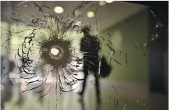  ?? PHILIPPE LOPEZ / AFP / GETTY ?? A bullet hole on a window in the entrance hall of a building on the Champs-Élysées on Friday.