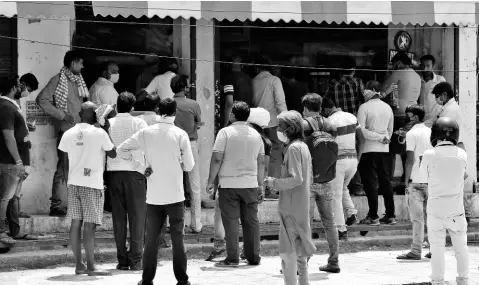  ?? AP ?? Indians wait to buy liquor outside one of the liquor shops which was reopened Monday after a six-week lockdown in Prayagraj, India, on Monday. India’s six-week coronaviru­s lockdown, which was supposed to end on Monday, has been extended for another two weeks, with a few relaxation­s.