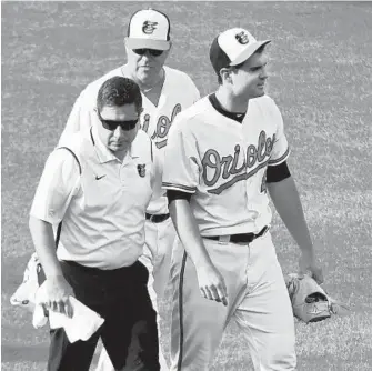  ?? KENNETH K. LAM/BALTIMORE SUN ?? Orioles reliever Richard Bleier, right, walks off the field with assistant trainer Mark Spires after “feeling something in the lat area” in the eighth inning. Bleier has a 1.93 ERA this season, the best on the active roster.
