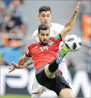  ?? AP PHOTO ?? Egypt’s Abdalla Said gets his foot on the ball as Uruguay’s Jose Gimenez challenges during a Group A match between those teams Friday at the 2018 World Cup in Yekaterinb­urg, Russia. Uruguay won 1-0.