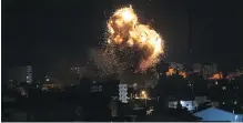  ??  ?? An Israeli air strike Monday hits the building housing the Al Aqsa TV station operated by Hamas in Gaza City.