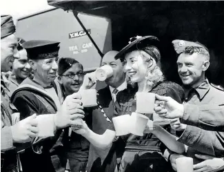  ?? GETTY IMAGES FILE ?? Forces Sweetheart Vera Lynn, acting on behalf of the Variety Artistes Ladies’ Guild, presents a mobile canteen in June 1942 to the mayor of Westminste­r who accepts it on behalf of the YMCA. Here she serves the first cups of tea to servicemen from the canteen, which is stationed in Trafalgar Square.