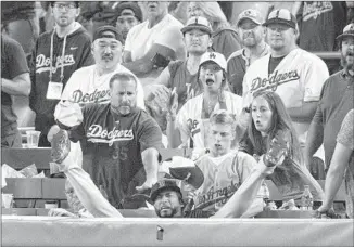  ?? Gina Ferazzi Los Angeles Times ?? IT WAS QUITE A GAME for Nunez, who fell into the stands after making a catch on a pop fly by Bellinger in the 13th inning. Max Muncy tagged up on the play and would score the tying run.