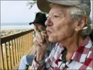  ?? GILLIAN FLACCUS — THE ASSOCIATED PRESS ?? Two-time cancer survivor and medical marijuana cardholder Bill Blazina, 73, smokes a marijuana joint on the deck of his neighbor’s home in Waldport, Ore. Blazina also uses a high-potency marijuana oil as a medical marijuana patient but he can’t afford it at a recreation­al marijuana store. Blazina has learned how to make his own oil in a rice cooker after watching online videos.