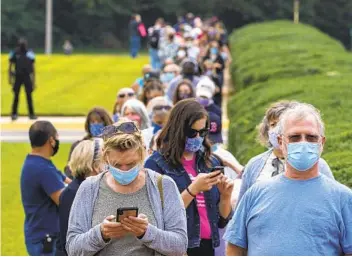  ?? TASOS KATOPODIS GETTY IMAGES ?? Voters stand in line Friday in order to cast ballots early at the Fairfax Government Center in Fairfax, Va. Voters waited up to four hours. Polls opened at 8 a.m., and some were in line as early as 5:45 in the morning.