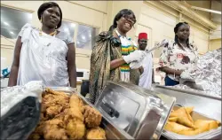  ?? @IMartensHe­rald ?? Rgena Deng, Kino Ykak, Agustino Akorkwag and Aggie Dang serve up South Sudanese food during the Southern Alberta Ethnic Associatio­n’s Heritage Day festivitie­s Monday at Exhibition Park.