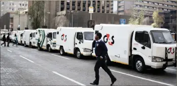  ?? PHOTO: REUTERS ?? A cash-in-transit worker walks past armoured vehicles parked on the street yesterday during a nationwide protest following a spate of deadly heists this year.