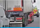  ??  ?? GRAYS: Police officers drive away a lorry, with black plastic visible at the rear, in which 39 dead bodies were discovered sparking a murder investigat­ion at Waterglade Industrial Park in Grays, east of London. — AFP