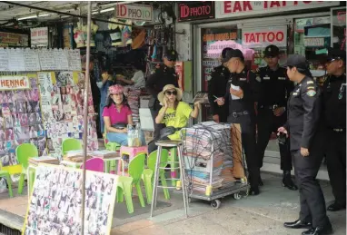  ?? PICTURE: REUTERS ?? KEEPING WATCH: Bangkok city officials chat to a street vendor at the Khao San tourist street in Bangkok, Thailand.