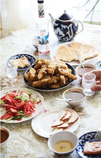  ??  ?? Above: carp with tomatoes, flatbreads, smoked cheese, tea and vodka. Opposite from top: a market in Khiva; a section of Kalta Minor minaret in Khiva.