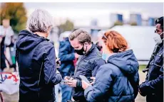  ?? RP-FOTO: ANNE ORTHEN ?? Bei der Demo auf den Oberkassel­er Rheinwiese­n ordneten Mitarbeite­r des OSD Verwarngel­der für Maskenverw­eigerer an.