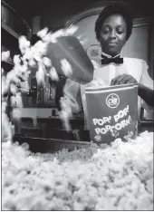  ?? BILL HOGAN — CHICAGO TRIBUNE ?? Diane Lee fills a bag with popcorn at the Water Tower Plitt Theatre on Dec. 4, 1986, in Chicago.