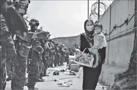  ?? AFP ?? US Marines guide evacuees during an evacuation effort at the Hamid Karzai Internatio­nal Airport in Kabul, Afghanista­n.