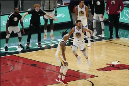  ?? PHOTOS BY NAM Y. HUH — THE ASSOCIATED PRESS ?? Golden State Warriors guard Damion Lee, left, celebrates with Stephen Curry after scoring the winning three-point basket during the second half against the Chicago Bulls in Chicago, Sunday. The Warriors won 129-128.