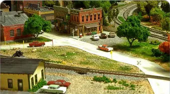  ??  ?? That N scale’s compact size isn’t a hindrance to detailed scenes is evident in the several urban areas Alex modeled. Many of the paved roads were made using Woodland Scenics road paving materials.