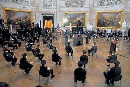  ?? Demetrius Freeman, AFP/Getty Images ?? Capitol Police officers and other guests pay their respects during a service for Brian Sicknick as he lies in honor Wednesday in the Rotunda of the U.S. Capitol in Washington.