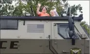  ?? JESI YOST - FOR MEDIANEWS GROUP ?? Linda Hettrick of Pottstown and Kaycee Cooper, 11, of Exeter, wave from the top of a Chesmont Emergency Response Team’s Mine-Resistant Ambush Protected vehicle.