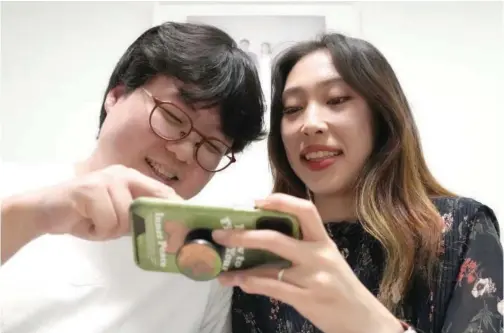  ?? Associated Press ?? Yoo Young Yi and her husband Jo Jun Hwi watch their Youtube channel at their home in Seoul, South Korea.