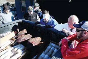  ??  ?? Rob Marquardt, Joe Kelso, Christian Crouse, and Richard Wallace Knight wait for John Bryant to sell country hams cured by his father, Freddie Bryant, in Murray, Kentucky, December 10. John is continuing his family’s traditiona­l yearly sale of hams...