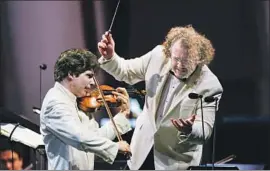  ?? Kent Nishimura Los Angeles Times ?? VIOLINIST Augustin Hadelich performs Sibelius’ Violin Concerto with conductor Stéphane Denève leading the L.A. Phil on Tuesday at the Hollywood Bowl.