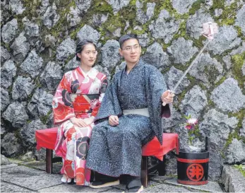  ??  ?? Die beiden Chinesen Song (li.) und Ji Yucheng schießen Selfies in Miet-Kimonos, die in Kyoto längst zu einer beliebten Attraktion bei Touristen aus aller Welt geworden sind.