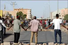  ?? AFP via Getty Images ?? Sudanese protesters form a chain near brick barricades during a demonstrat­ion calling for a return to civilian rule in the capital Khartoum, on Sunday.