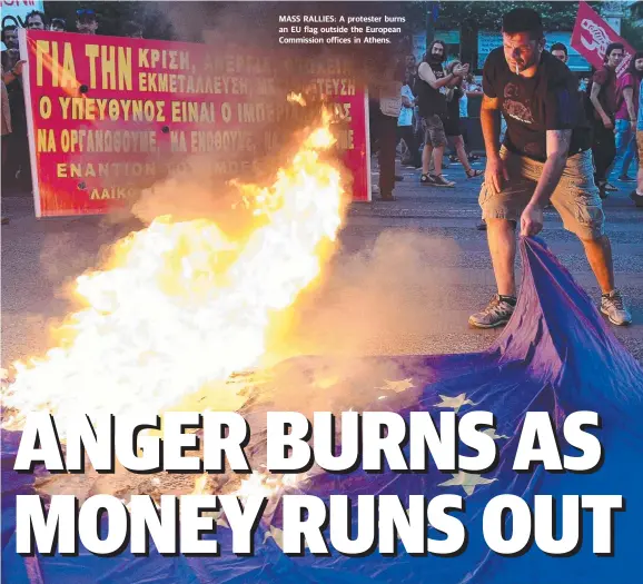  ??  ?? MASS RALLIES: A protester burns an EU flag outside the European Commission offices in Athens.