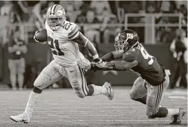  ?? Ron Jenkins / Associated Press ?? Freed from the immediate threat of a six-game suspension, Cowboys running back Ezekiel Elliott escapes Giants linebacker B.J. Goodson at AT&T Stadium.