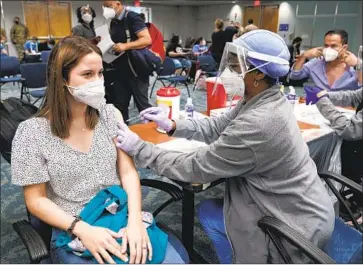  ?? Marta Lavandier Associated Press ?? NATALIA DUBOM receives a COVID-19 vaccinatio­n at Miami Internatio­nal Airport in May. White House officials said vaccinatio­n rates are rising in some states, including Florida, where COVID-19 cases are surging.