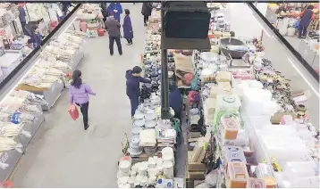  ??  ?? People walk pass vendors at a market in Yanji, Jilin Province, China. The official newspaper of the government of Jilin province, where Yanji is located, said in a September article that North Korean and Russian seafood is processed in a town near...