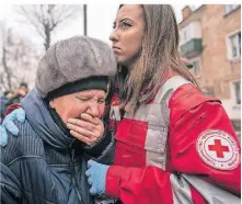  ?? FOTO: DPA ?? Eine Frau weint in den Armen einer Rettungskr­aft vor dem Gebäude, das durch einen Angriff in Krivyi Rih zerstört wurde.