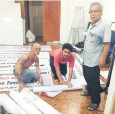  ??  ?? Peter (left) and another key organiser Bill Jugah and Sadia secretary Nicholas Mujah Ason (right) prepare materials for the peaceful Nov 13 rally.