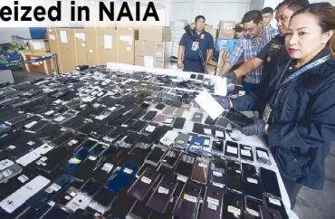  ?? RUDY SANTOS ?? Bureau of Customs officials show smartphone­s smuggled from South Korea in a press conference at the Ninoy Aquino Internatio­nal Airport yesterday.