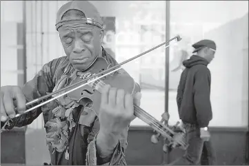  ?? Rick Loomis/Los Angeles Times/TNS ?? ■ Nathaniel Ayers plays the violin in downtown Los Angeles in 2008.