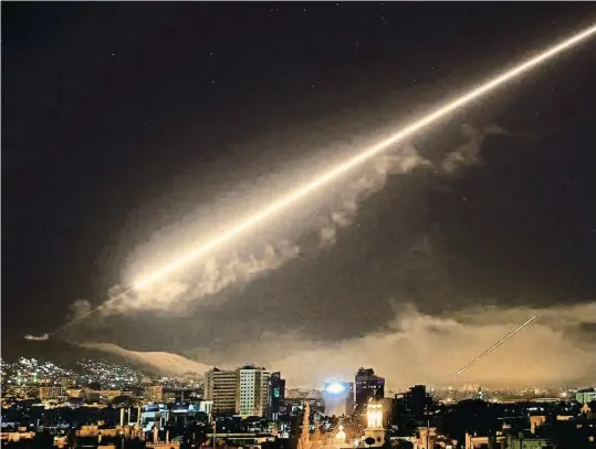  ?? HASSAN AMMAR / AP ?? El cielo de Damasco iluminado la madrugada de ayer por la caída de los misiles aliados contra instalacio­nes de armas químicas